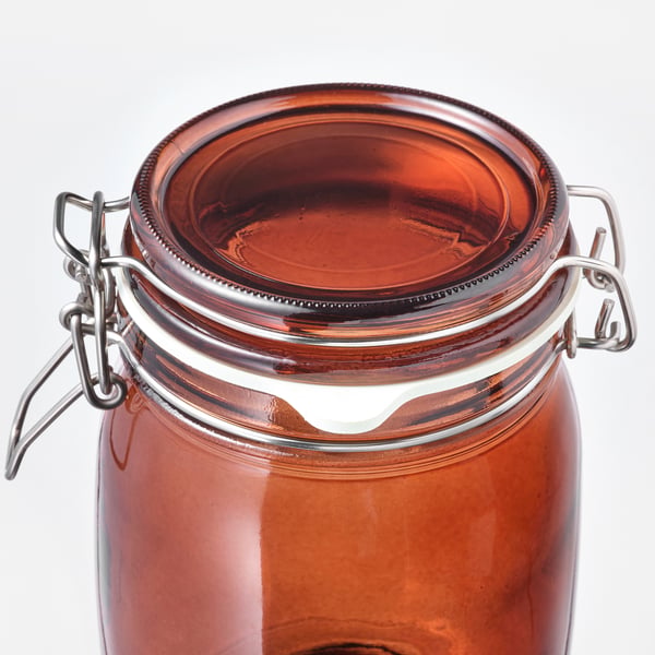 Clear glass jar with brown tinted lid, metallic clasp, sealed rubber lining.
