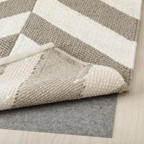 Geometric wool rug in grey & beige with anti-slip pad.