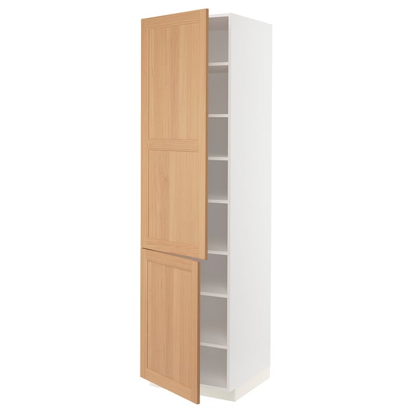 A white METOD kitchen cabinet with oak doors partially open, revealing adjustable shelves inside.