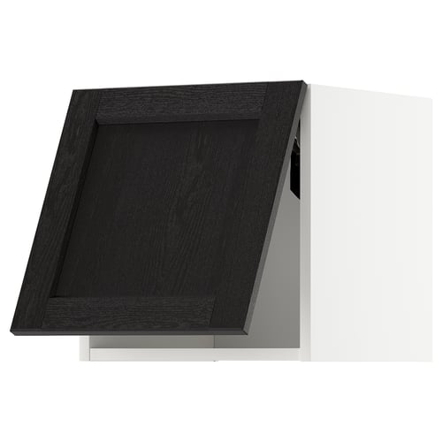 Black kitchen cabinet with a traditional design, made of stained wood. A single door with bevelled edges, set against a white wall.