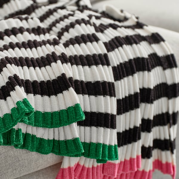 Soft, striped chenille throw with green, black, white, and pink bands, neatly folded.