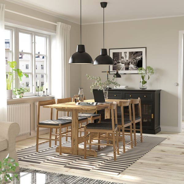 Wooden dining table with natural finish, chairs, vase, rug, pendant lights, sideboard & picture.