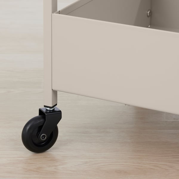 Close-up of robust, white wheeled storage trolley with black castor on wooden floor.
