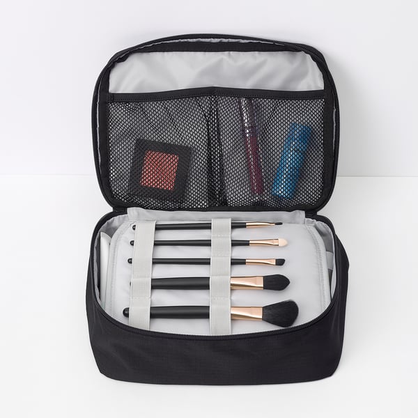 Black toiletry bag with makeup brushes, mesh pockets, and organised compartments.