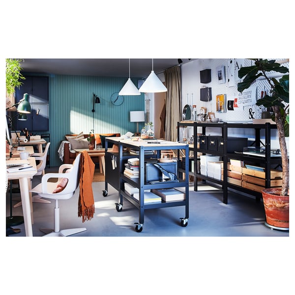 Modern home office with blue ODGER chairs, wooden tables, plants, and bright lighting.