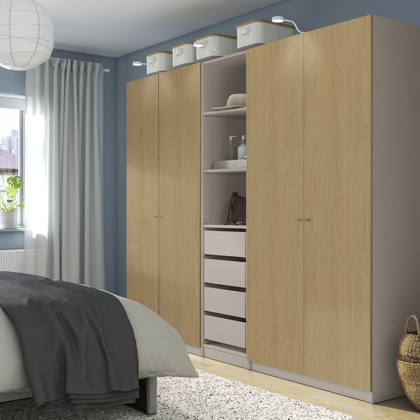Brown PAX wardrobe in bedroom, with shelves, drawers, & wall baskets.