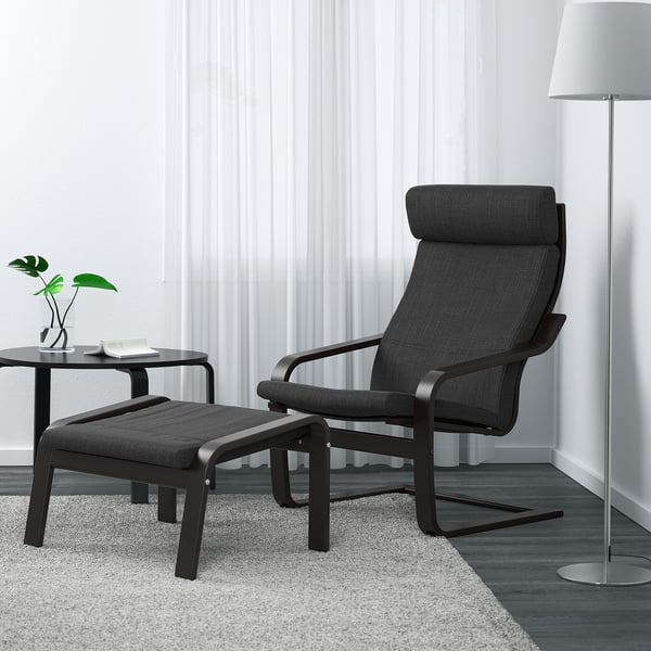 Modern room with POÄNG chair, footstool, plant, book, and lamp.