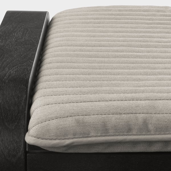 Close-up of modern footstool with ribbed fabric and sleek, dark frame, showcasing quality craftsmanship.
