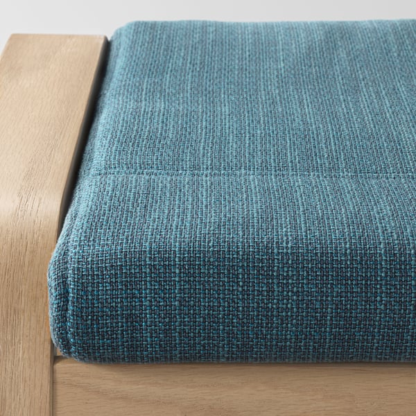 Close-up of wooden framed footrest with teal cushion, showcasing quality craftsmanship and comfortable design.
