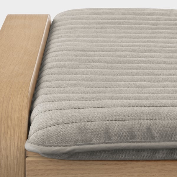 Close-up of a sturdy, cushioned footstool beside a wooden seat, showing high-quality materials and comfortable design.