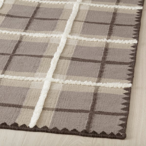 Tartan wool rug, hand-woven with brown and grey tones, displaying high craftsmanship with visible texture and intricate pattern.