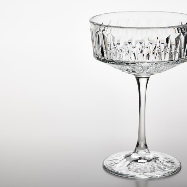 Elegant crystal glass with intricate cut patterns, standing on a reflective surface. Perfect for serving drinks.