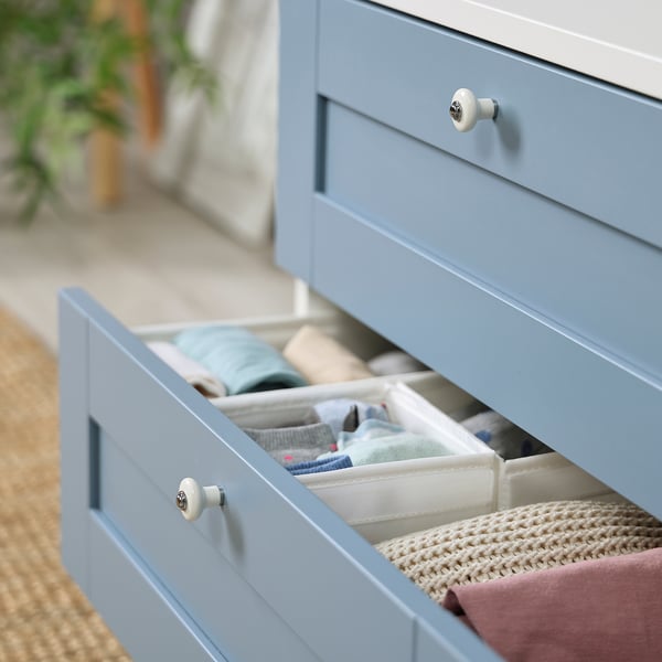 Blue dresser, open drawer, organised clothes.