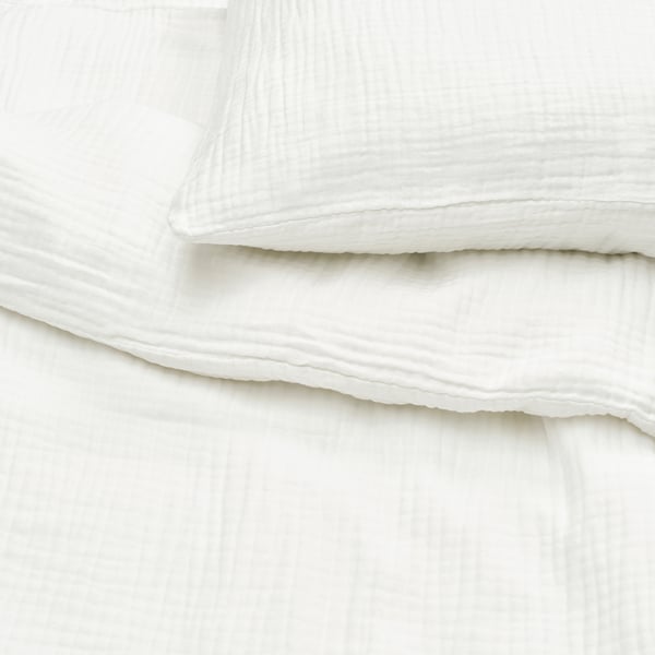 Clean, crisp white bedding with smooth, breathable fabric, neatly arranged, suggesting luxury and comfort.