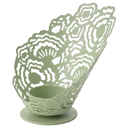 Green metal tealight holder with intricate cutouts for shadow effects.