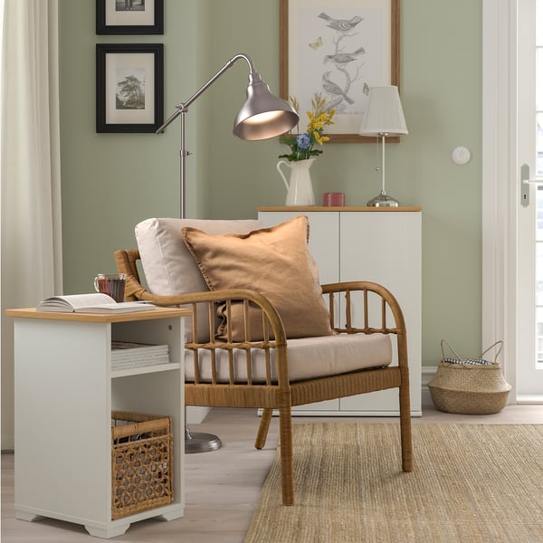 White SKRUVBY side table with magazine and basket, next to wooden chair on beige rug.