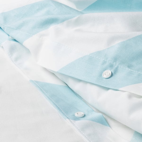 A close-up of a light blue and white striped duvet cover, showcasing its quality fabric and neatly sewn design.