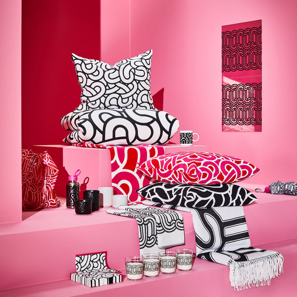 Vibrant pink room showcasing SÖTRÖNN black-white abstract patterned pillows, blankets, and home decor items.