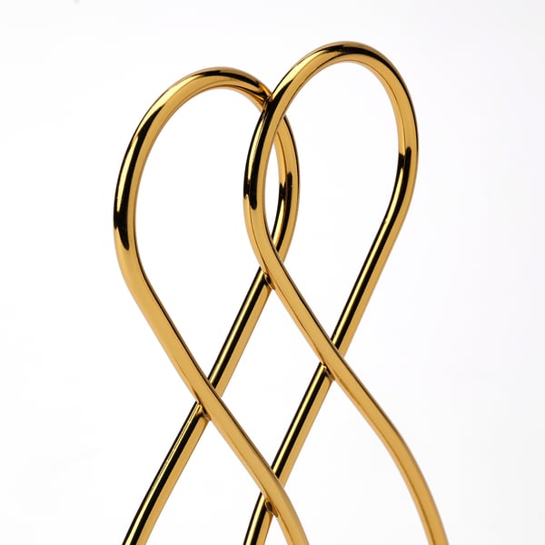 Gold-colored metallic bookend, with a sleek, modern design, displaying intricate wire patterns for a decorative and functional appeal.