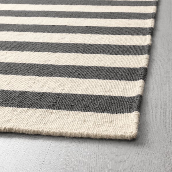 Close-up of a handwoven striped rug with alternating grey and white stripes, showcasing its high-quality texture and craftsmanship.