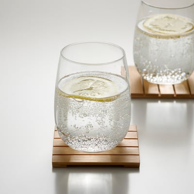 Two glasses filled with bubbly drinks on wooden coasters.