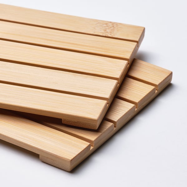 A stack of bamboo coasters, neatly arranged, with a light wood finish, suitable for table use.