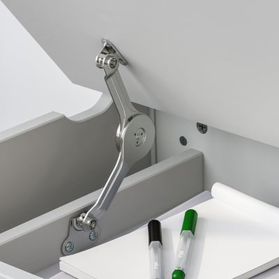 A childrens desk with a lift-up top and storage, featuring an adjustable lid stay for safety.