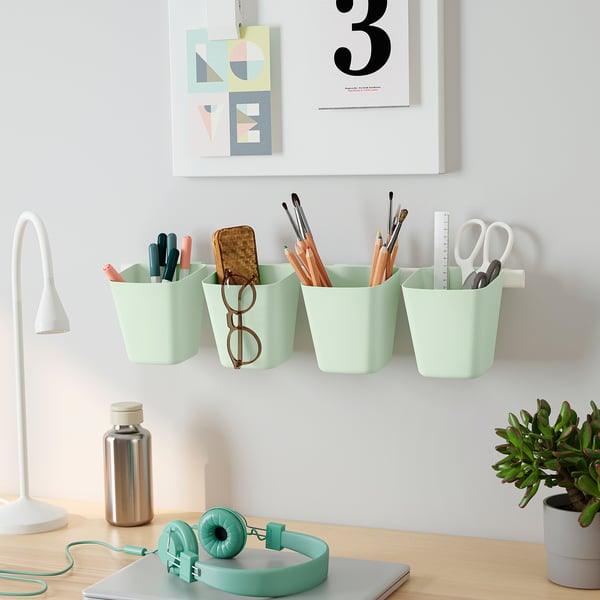 Desk with mint storage, office supplies, lamp, phone & poster.