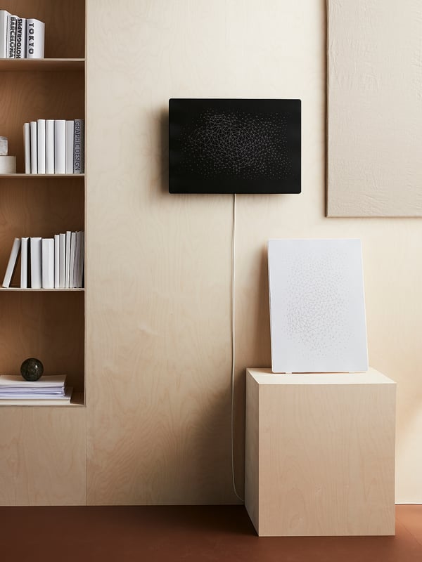 Modern home setup: ikea SYMFONISK speaker, picture frame speaker, and bookshelf with decor.