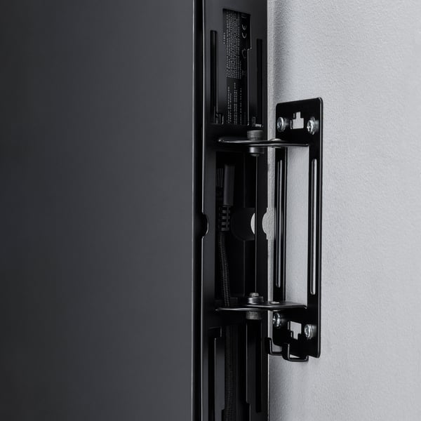 Black wall-mounted speaker bracket securely fastened to the wall, showcasing sturdy design and robust construction.