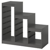 Depicts a dark grey TROFAST storage unit with multiple compartments for organising items, designed with a modular structure.