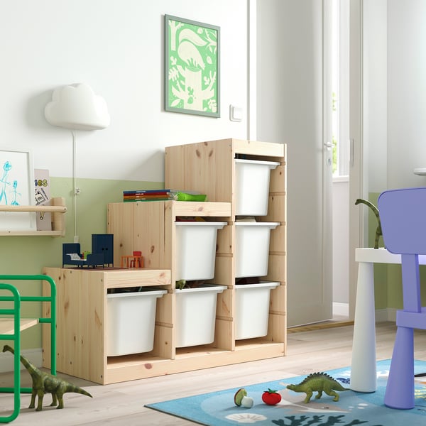 Bright kids room with TROFAST storage: light wood frame, white plastic bins, green dinosaur toys, and blue rug. Perfect for small spaces.