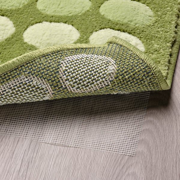 Green door mat with white dots and anti-slip mesh underside.