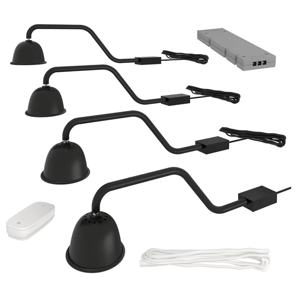 A black TVÄRDRAG lamp kit for cabinet lighting, including four curved arms with domed lamps, a power supply, and a wireless dimmer.
