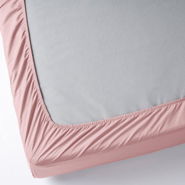 A fitted bed sheet with pink elastic edges covering a grey mattress, showcasing its secure fit and texture.
