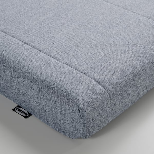 Close-up of neat, light grey fabric bed, branded IKEA, showing quality stitching and soft texture.