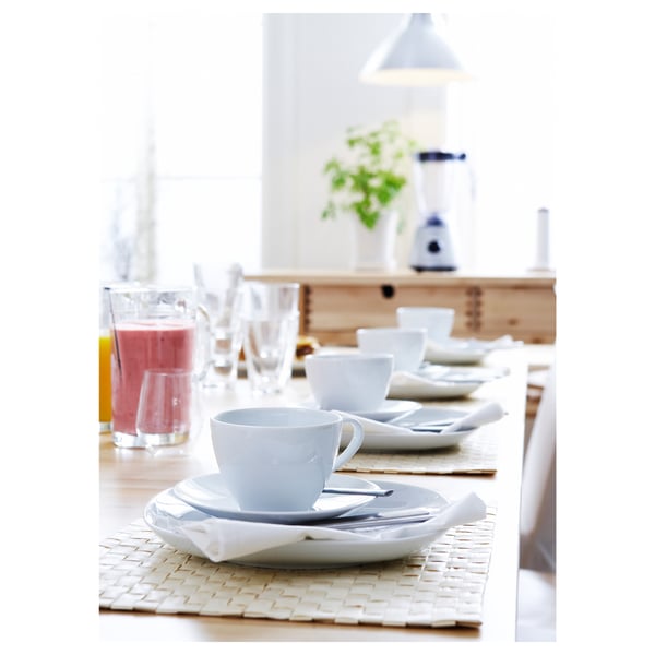 Minimalist table setting with VÄRDERA dinnerware, placemats, and colourful juices.