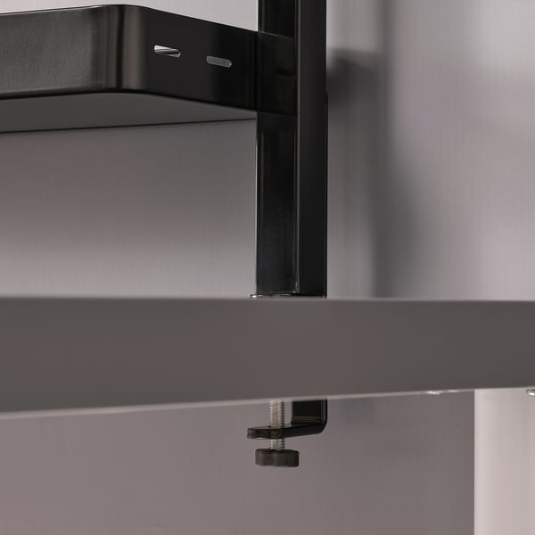 Black shelf unit on table, adjustable with scratch protection.