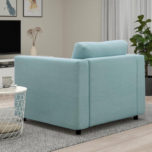 Blue upholstered armchair, part of modular VIMLE sofa series, placed on a rug in living space with a side table and plant nearby.