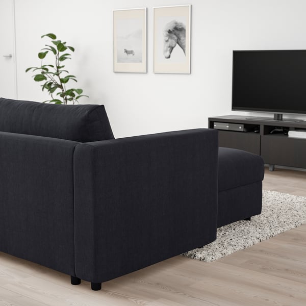 Modern living room with large black VIMLE sofa, flat screen tv, and plant.