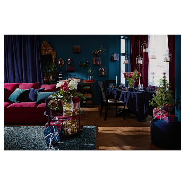 Decorative living room with dark teal walls, red sofa, wooden table, and lanterns.