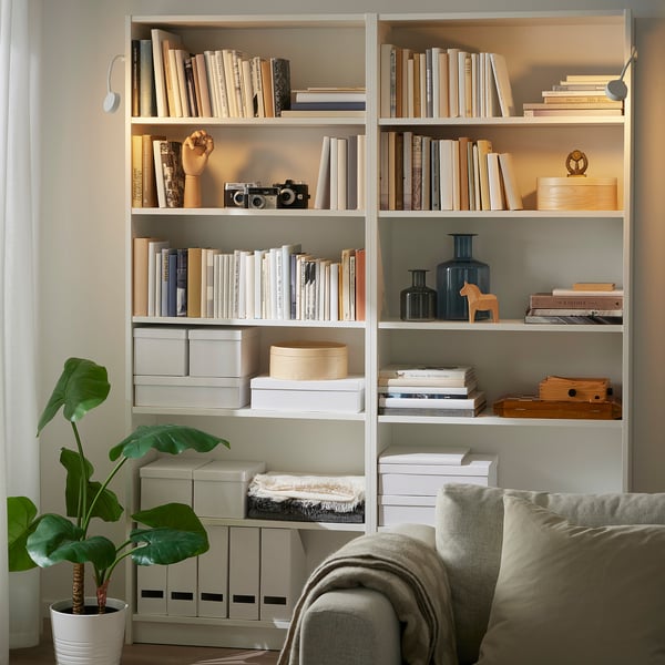 Bookshelf with items, YTBERG lamp, plant, chair, blanket.