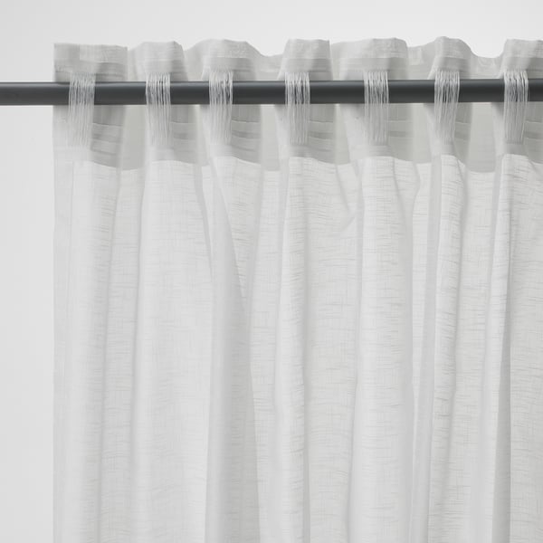 White sheer curtains hanging, with a black rod and tabs at the top, creating folds.