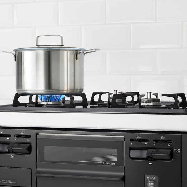 Modern gas stove with three burners, one in use.