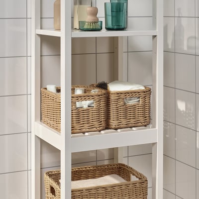 BEKNA wicker baskets organise bathroom essentials on a white shelf, providing rustic charm and practical storage.