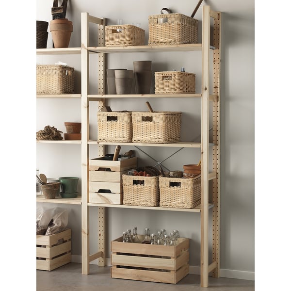 Wooden shelves with wicker baskets and gardening tools. Baskets in natural colour hold jars and larger tools. Taller than neighbouring shelves.
