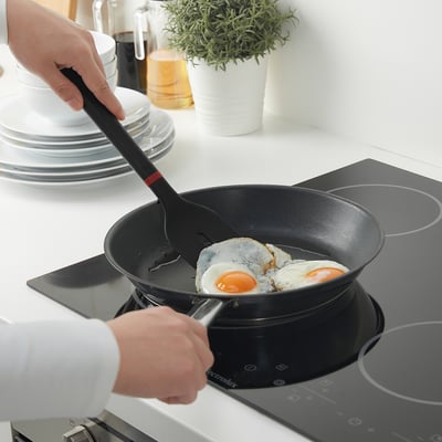 Cooking eggs in non-stick pan with silicone spatula. Spatulas soft edges protect pan, with hole for easy storage.