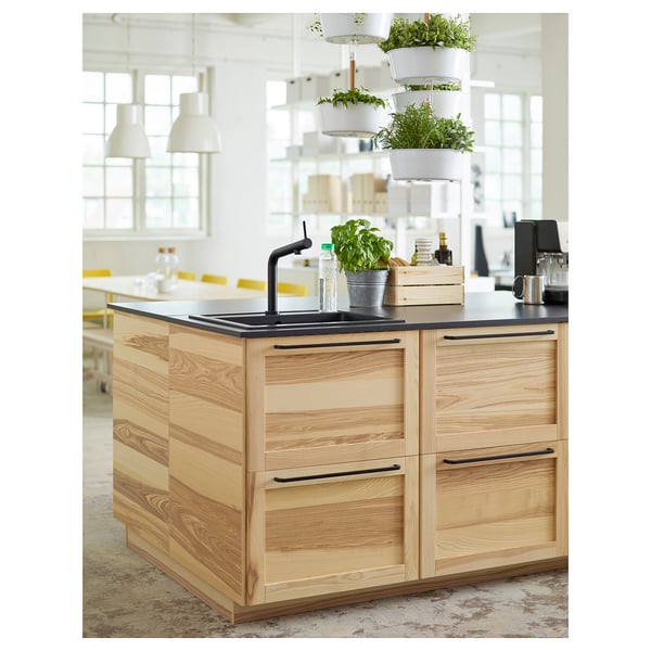Modern kitchen island with BOSJÖN black tap, wooden cabinets, hanging plants, and countertop appliances.