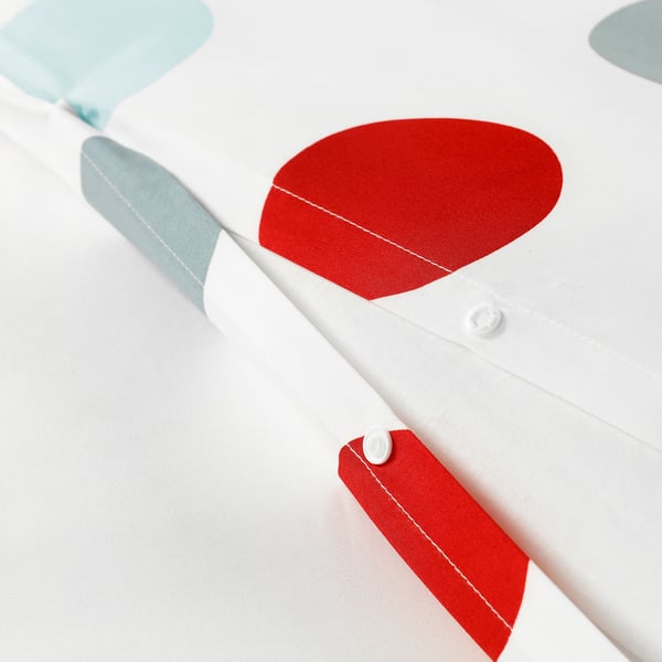 Close-up of bedding with red circular pattern. Button closure visible; soft, breathable fabric.