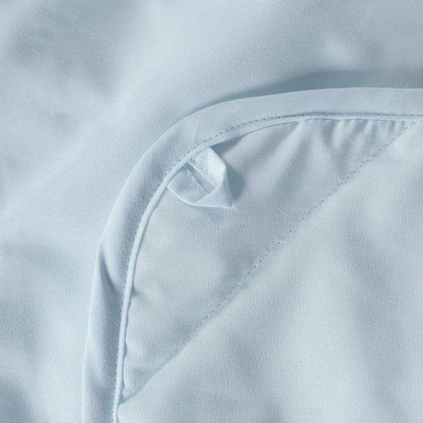 Close-up of a soft, white duvet with neat stitching, showcasing its smooth, lightweight texture.